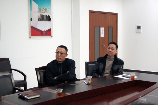 圖5、宏陶拋光磚銷售副總張彥（左一）、宏陶廣東線銷售副總龐永江（右一）認(rèn)真觀看參評(píng)專賣店幻燈片播放效果
